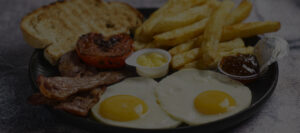 A plate featuring scrambled eggs, golden toast, and crispy French fries, arranged appetizingly for breakfast.